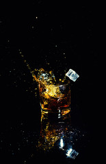 Isolated shot of whiskey with splash on black background
