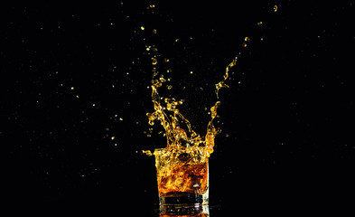 Isolated shot of whiskey with splash on black background