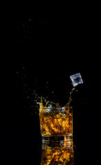 Isolated shot of whiskey with splash on black background