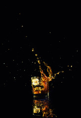 Obraz na płótnie Canvas Isolated shot of whiskey with splash on black background