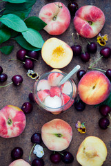 Cocktail with organic fresh peaches and cherries