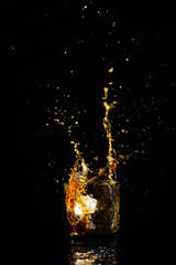 Isolated shot of whiskey with splash on black background