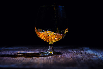 glass with cognac on a wooden background