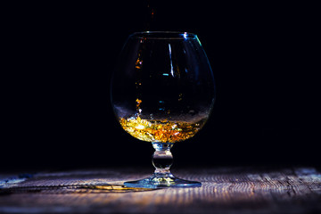 glass with cognac on a wooden background
