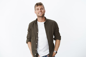 Relaxed, friendly good-looking european guy with bristle smiling joyfully with white healthy teeth...