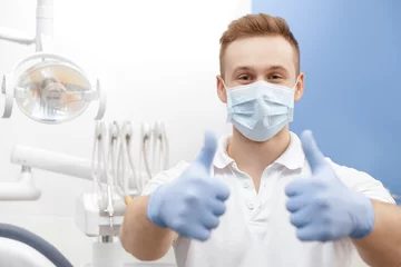 Peel and stick wall murals Dentists Always professional! Professional dentist wearing protective mask and gloves showing thumbs up posing at his dental clinic copyspace professionalism gesture approved confidence medicine health people 