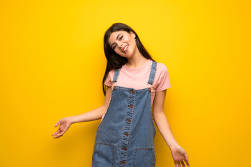 Teenager girl over yellow wall smiling