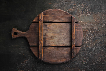 Kitchen board on a dark background. Top view. Free copy space.