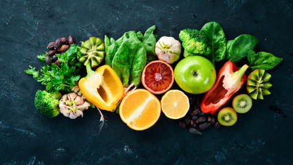 Healthy vegetarian food: Orange, lemon, apple, rose, garlic, broccoli, apple, kiwi, spinach. Top view. free space for your text.
