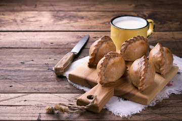 Russian traditional rye pies with egg, kokurki, on a wooden table