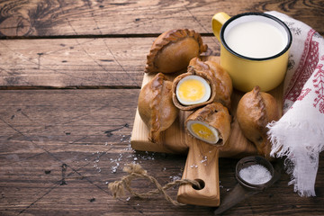 Russian traditional rye pies with egg, kokurki, on a wooden table
