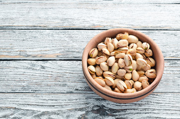 Pistachios on a white wooden background. Top view. Free space for your text.