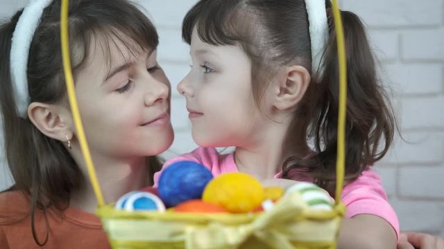 Preparing for Easter. Cute little sisters with a basket of Easter eggs.