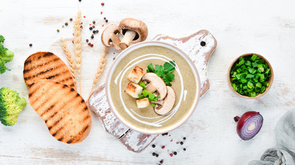 Cream soup of mushrooms in a bowl with toasted bread. Dietary food. Top view.