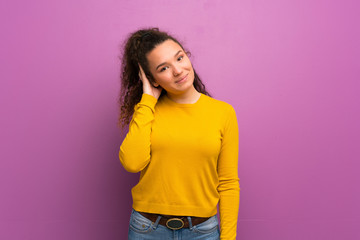 Teenager girl over purple wall thinking an idea