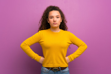 Teenager girl over purple wall angry