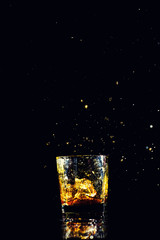 Isolated shot of whiskey with splash on black background, brandy in a glass