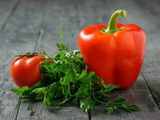 Bulgarian red pepper with tomato and parsley on the black table. Vegetarian food.