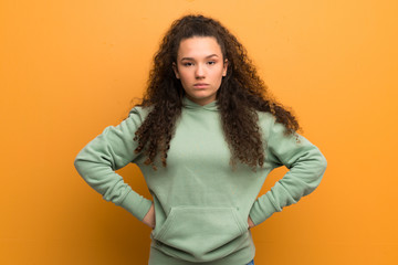 Teenager girl over ocher wall angry