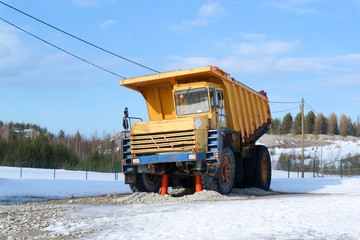 old hard worker - big old yellow dump truck on the snow