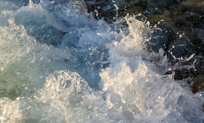 pebble stones on the sea beach, the rolling waves of the sea with foam