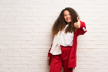 Teenager sport girl with curly hair with thumbs up because something good has happened