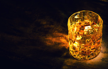 whiskey with ice cubes on wooden background