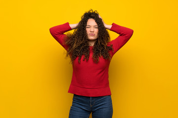 Teenager girl with red sweater over yellow wall