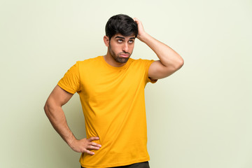 Young man over pink wall with an expression of frustration and not understanding