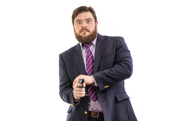 Portrait of a big handsome serious bearded business man with gun in dark suit and bright blue tie, isolated on white