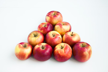 Red apples in the form of pyramid on the white ground