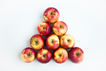 Red apples in the form of pyramid on the white ground