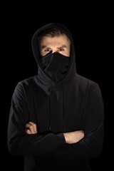 faceless man with open eyes in hoodie standing isolated on black