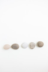 Pebbles in a row on the white ground, flat lay