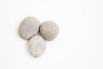 Fototapeta na wymiar Three pebbles on the white ground