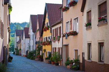 A narrow street with beautiful bright houses and flowers on it. Veitshoechheim, Germany