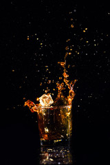 Isolated shot of whiskey with splash on black background