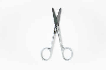 Opened scissors on the white ground 
