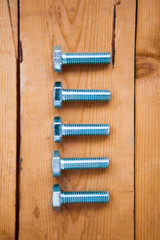 Bolts in a row on the wood ground, flat lay