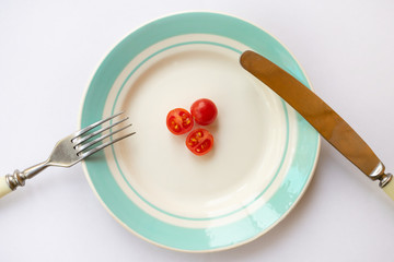 Plate with cherry tomatoes. Concept of hard dieting and weight loss.
