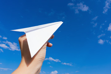Paper plane in young girl's hand. Concept of freedom.