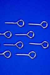 horizontal pattern of hook screws on blue background