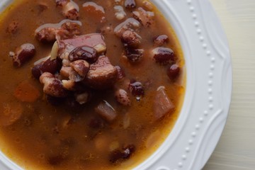 Homemade bean soup , vegetables ,bacon and spices. Detail of bowl of bean soup with large beans