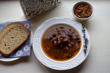 Homemade bean soup , vegetables ,bacon and spices. Detail of bowl of bean soup with large beans