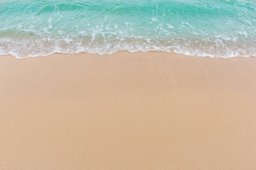 Naklejka na ściany i meble Soft wave of sea on empty sandy beach Background with copy space