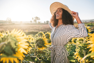 Happy young black woman in a sunflower field - Powered by Adobe