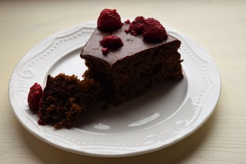 Delicious chocolate pie decorated with raspberries and sweets . Cooked at home.