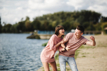Fototapeta premium crazy young couple emotionally having fun, kissing and hugging outdoors. Love and tenderness, romance, family, emotions, fun. having fun together