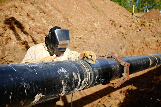 electric welder welds a pipe
