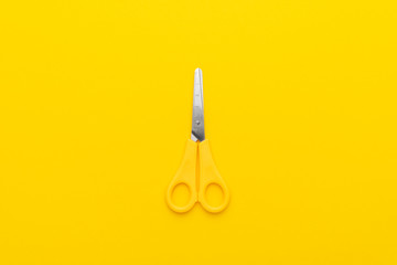 children's scissors on the yellow background with copy space